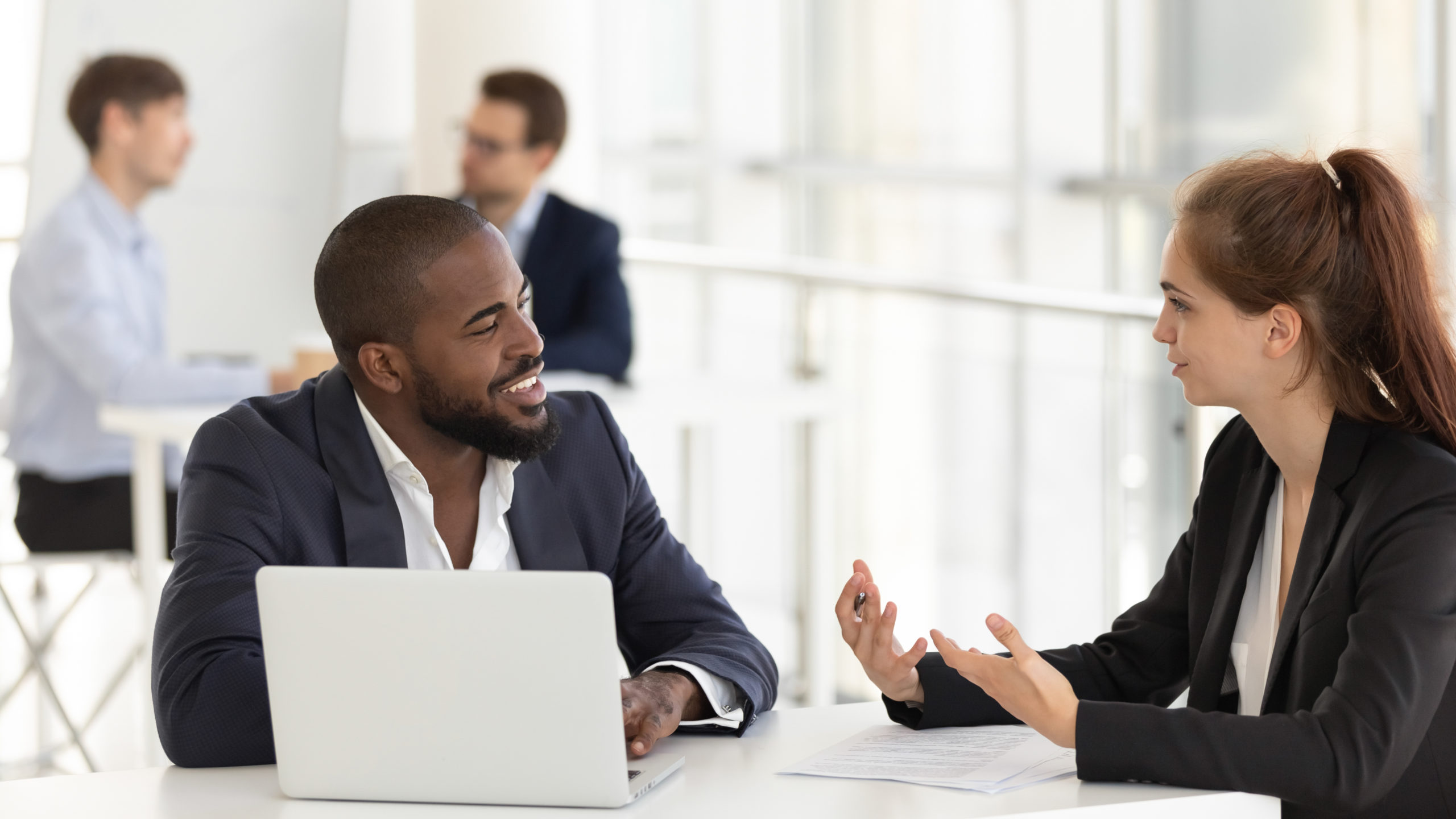 Confident female speak with african American male client Um homem e uma mulher em uma reunião